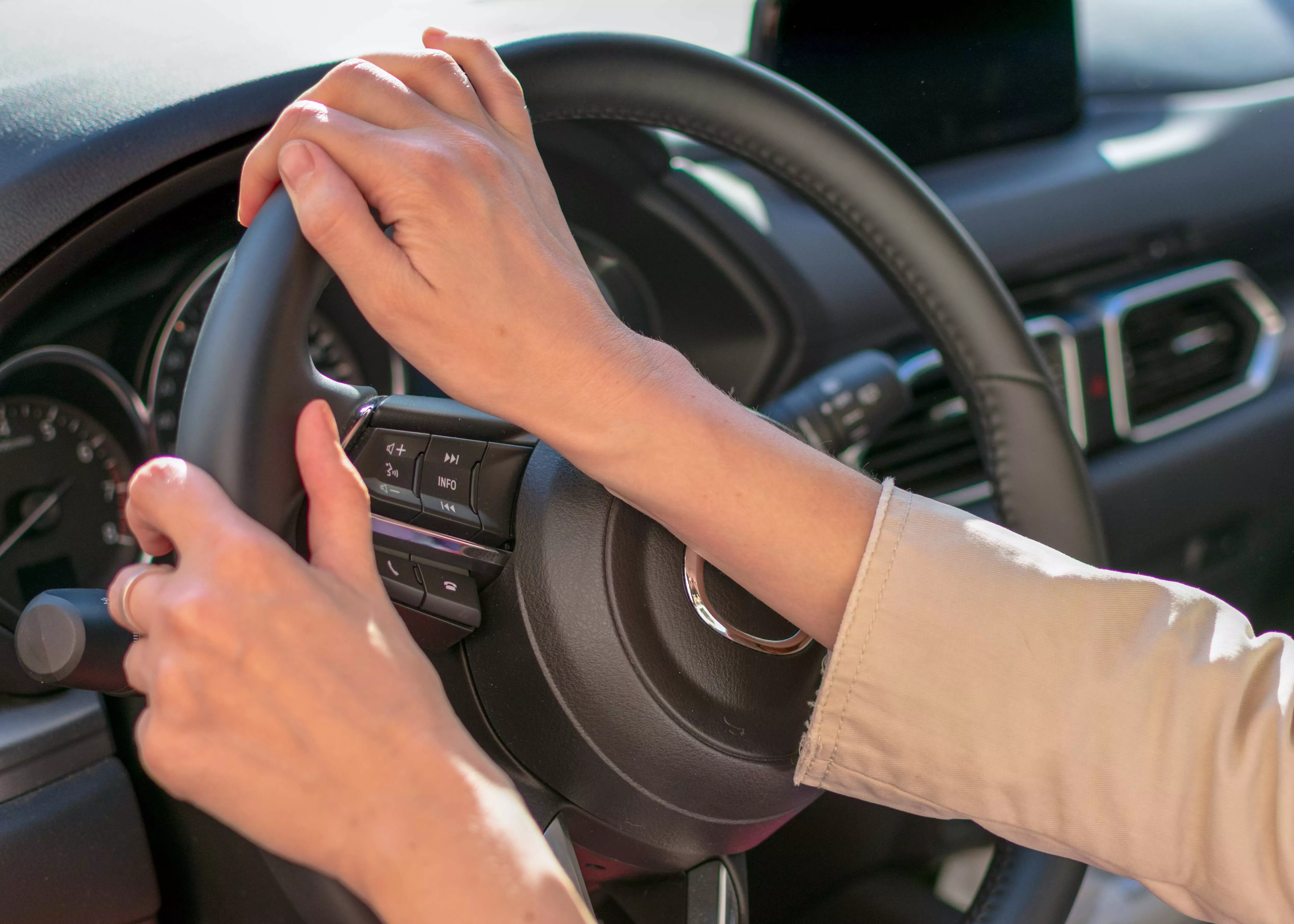 Hände einer Frau am Lenkrad eines Autos